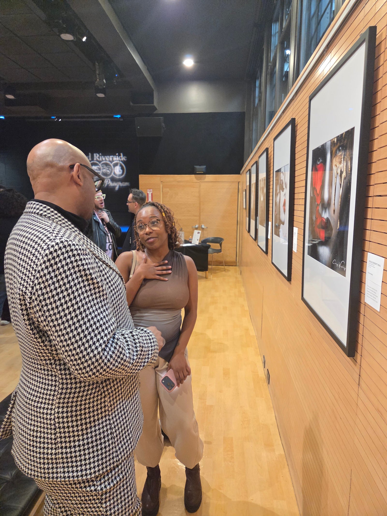 Corey Wesley discussing one of the exhibited works with Tiffany of Brown Style Magazine during opening night of Unapologetic Faces in New York City.