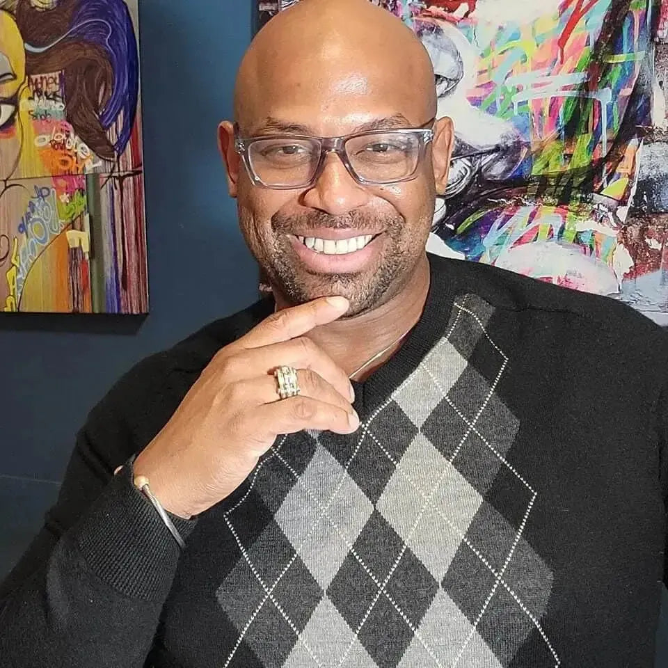 Portrait of artist and founder Corey Wesley, with bold contemporary artwork in the background.